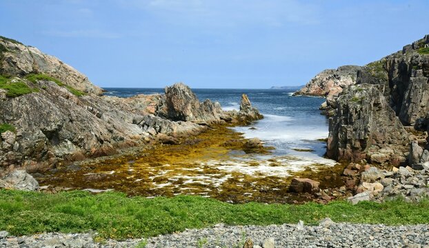 picturesque cove with surf  and sea stacks  near the the natural arch  on a sunny summer day along the lower little harbour trail on south twillingate island in northeastern newfoundland, canada