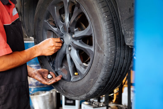 Mechanic changing car tire removing lug nuts