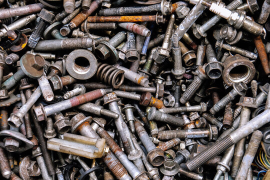 Rusty metal bolts and screws creating industrial background