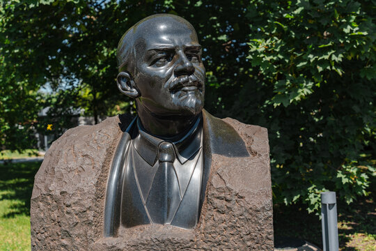 A stone monument to Vladimir Lenin standing on a street. The Soviet-era statue of the revolutionary leader is mounted on a pedestal, surrounded by an urban setting. Moscow, Russia - 19 July 2026