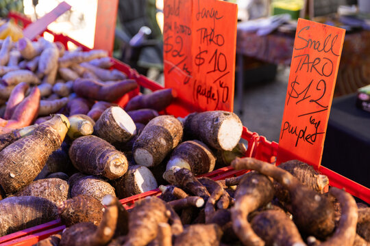 Piles of taro roots and other tubers displayed in red crates