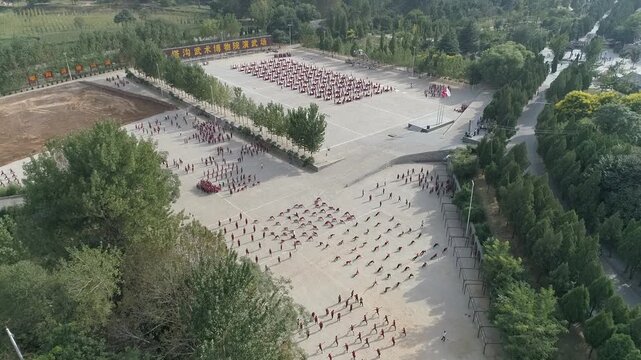 Raw footage  drone  of Shaolin temple training Martial arts in China. Training Pupils Martial Arts School on the Square. Students practice martial art in Shaolin Temple in Dengfeng city, Henan.