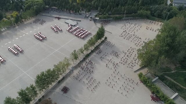 Raw footage  drone  of Shaolin temple training Martial arts in China. Training Pupils Martial Arts School on the Square. Students practice martial art in Shaolin Temple in Dengfeng city, Henan.