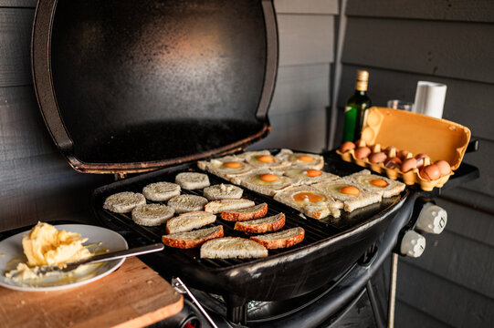 Slices of bread with eggs cooking on a barbecue grill in Crackenback