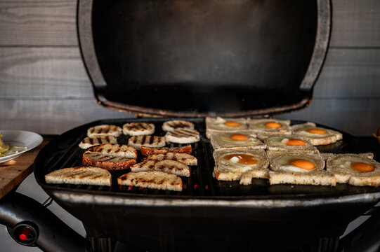 Slices of bread with eggs cooking on a barbecue grill in Crackenback