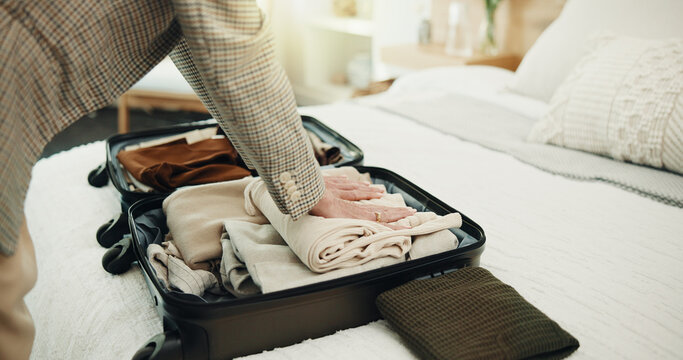 Hands, packing and business travel with suitcase in bedroom, sorting and plan for journey in house. Organizing, clothes and person with luggage, employee and preparing international trip in home