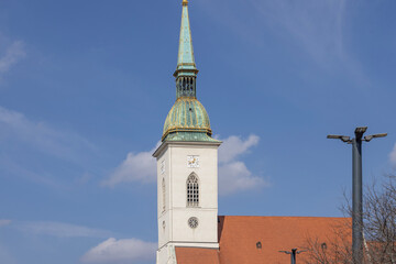 Obraz premium St Martin's Cathedral church with gothic spire and green copper roof under blue sky, Bratislava, Slovakia