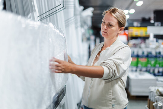 Woman Examining Large White Product in Home Improvement Store