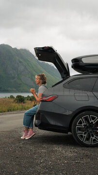 Woman taking a coffee break on a scenic road trip