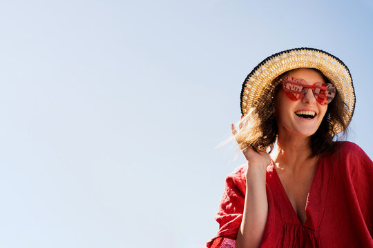 Woman with Heart Sunglasses and Straw Hat. Aesthetic Fashion Portrait