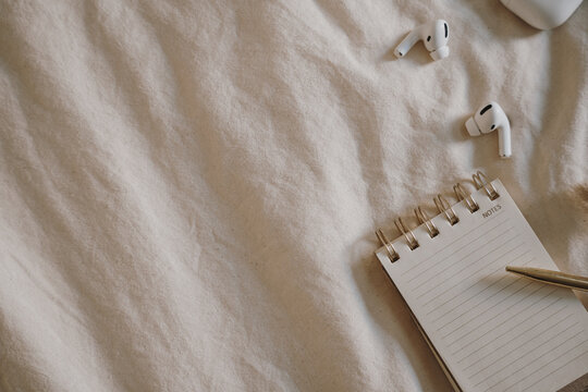 Cozy Minimalist Workspace with Earbuds, Notebook, and Pen
