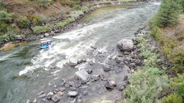 Riverside adventure scene with rafters dodging boulders and rapids
