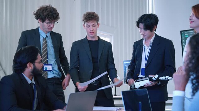 Engineering professionals reviewing a robotic hand prototype and technical documents during a collaborative technology development meeting.
