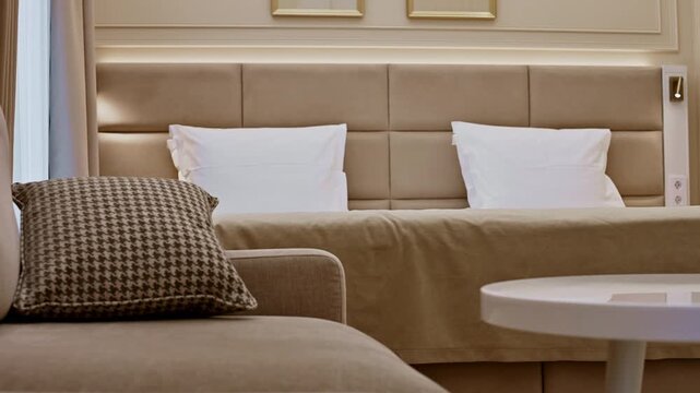 Hotel room interior with bed and sofa panning shot