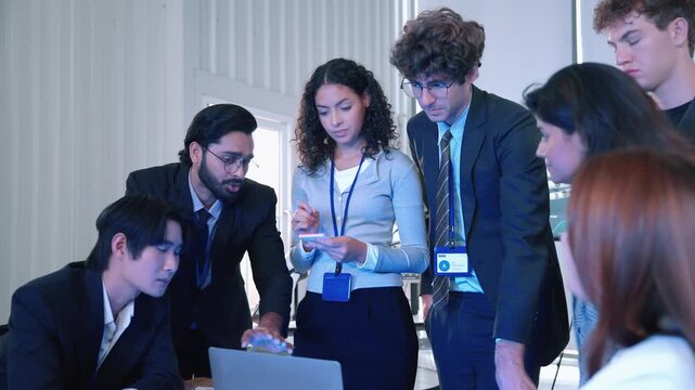 Engineering professionals working together around a laptop to review technical information and develop a robotics technology project in a modern office.
