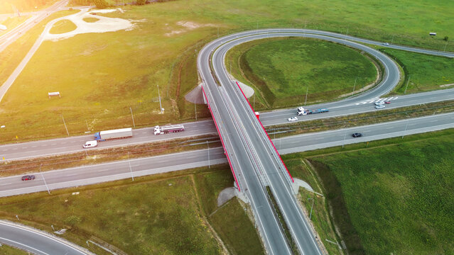 Highway traffic moving quickly between green woods