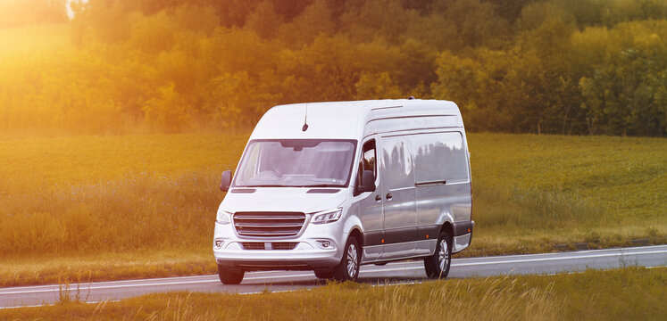 White delivery truck on a road through the fields