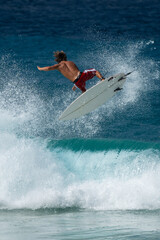 Obraz premium Surfer performing aerial maneuver above breaking ocean wave