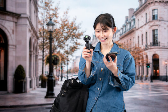海外の街を歩きながら動画を撮影する女性