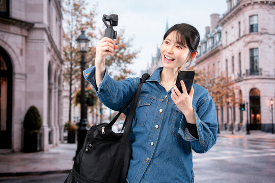 海外の街を歩きながら動画を撮影する女性