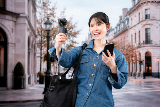 海外の街を歩きながら動画を撮影する女性