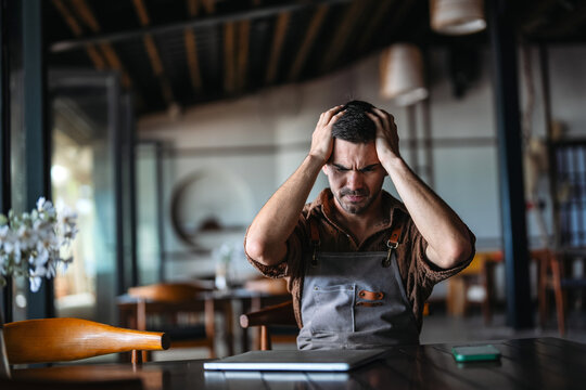 Worried restaurant owner contemplating business decisions during a financial crisis