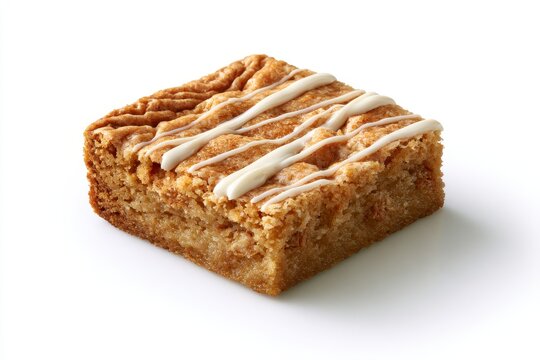 A square piece of blondie brownie with white icing drizzle isolated on white background