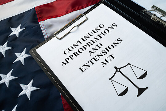 Continuing Appropriations and Extensions Act document on clipboard on USA flag background, federal budget legislation concept