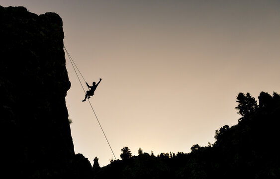 Extreme sport concept featuring a climber silhouette against a golden hour sky