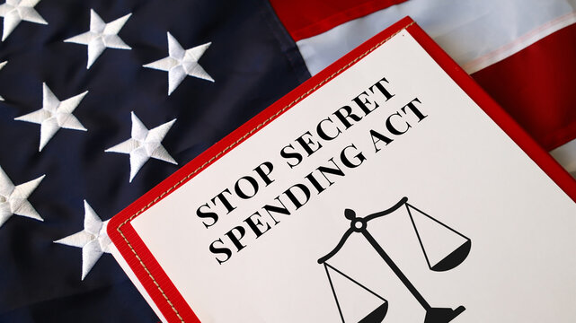 Stop Secret Spending Act document on clipboard on USA flag background, federal financial transparency legislation concept