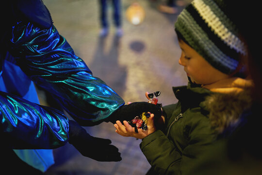 Boy receiving candy from performer at Christmas Three Kings Parade