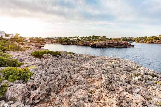 Rugged rocks above peaceful cove in Cala d'Or, Mallorca, Spain.