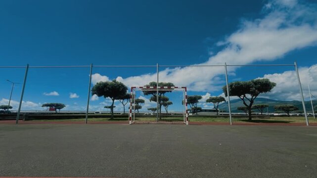 Empty street soccer goal with net on an outdoor futsal court under blue sky with clouds, S&atilde;o Miguel, Azores, Portugal