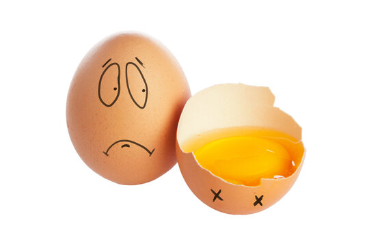 Funny broken egg with a sad face and an egg shell lying next to it on a white background