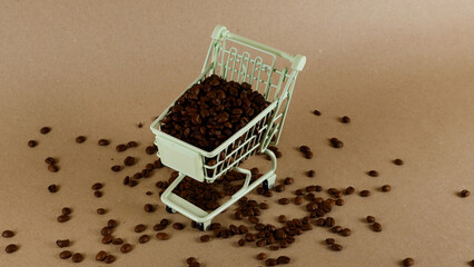 Miniature green shopping cart filled with dark roasted coffee beans, with many beans scattered around on a light brown background, illustrating concepts of coffee retail and purchasing © Dark Artistic