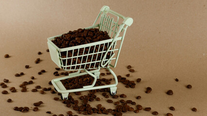 Roasted coffee beans filling a tiny shopping cart on a light brown surface, with scattered beans representing a purchase or fresh selection for a morning beverage © Dark Artistic