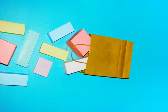 Colorful geometric blocks spilling from a shopping bag on blue