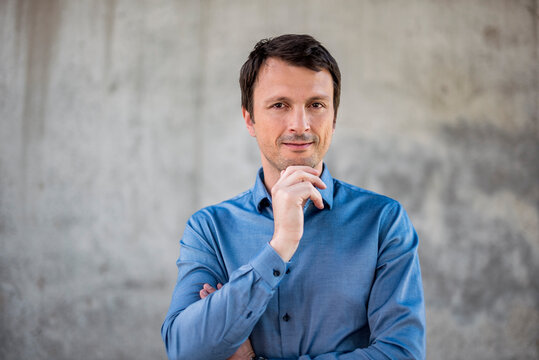 Portrait of confident businessman in front of concrete wall