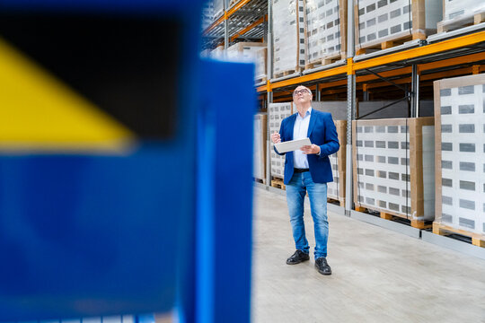 Male manager checks inventory with a tablet in the warehouse