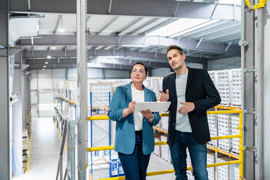 Manager and supervisor plan logistics with tablet in warehouse