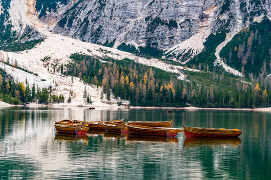 A wooden boat floats on the calm water of Lake Braies in Italy