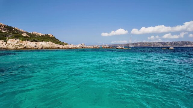 Panoramic view of the turquoise bay with a rocky coastline with yachts and boats off the coast of Spargi Island in the La Maddalena archipelago, Sardinia, Italy