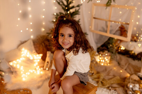 A smiling girl enjoys a cozy Christmas holiday at home