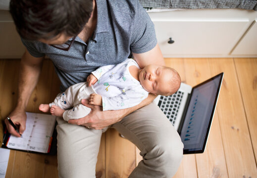 Father with his baby daughter working from home