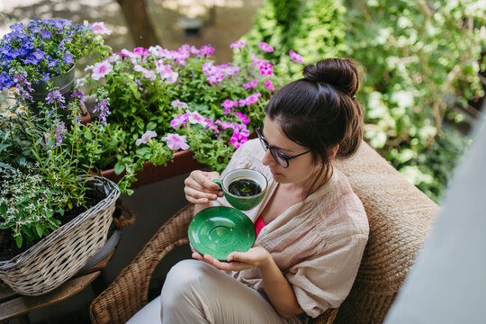Woman enjoying her free time and a cup of coffee on the balcony