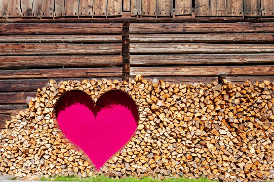 A red heart decorates a firewood wall at an alpine hut in Austria