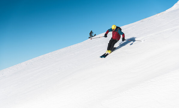 Mature man skiing on mountain slope against sky
