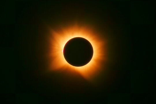 A total solar eclipse shows the glowing corona in the dark sky