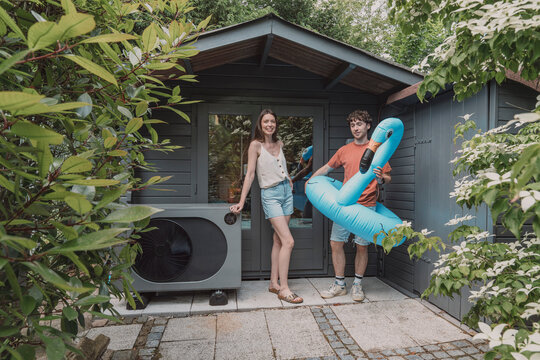 Woman and man show a heat pump and a flamingo outdoors