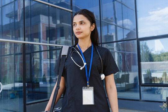 Female doctor with stethoscope relaxing outside the hospital